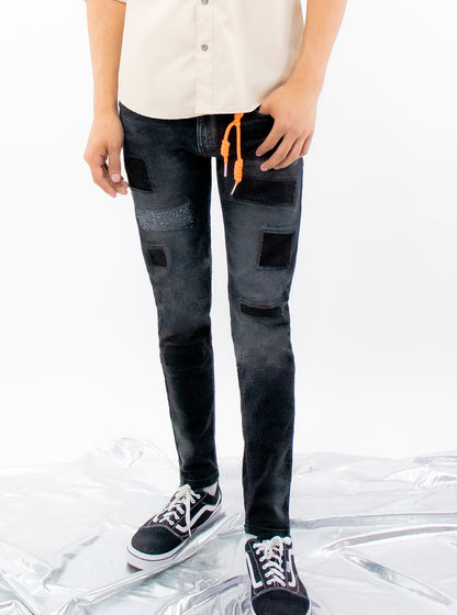 Jeans skinny de color negro deslavado con parches